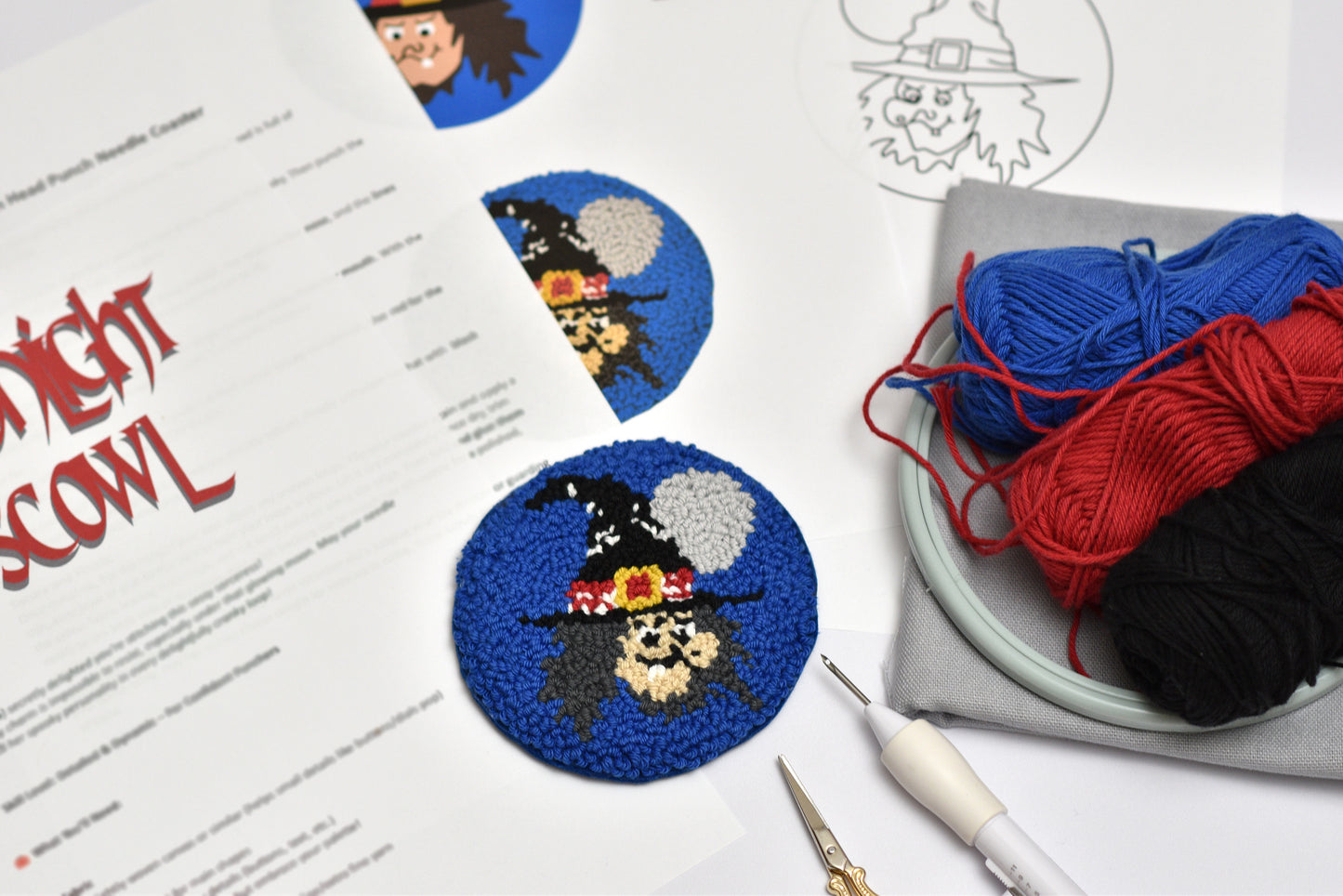 Halloween-themed punch needle project with yarn and tools on a table