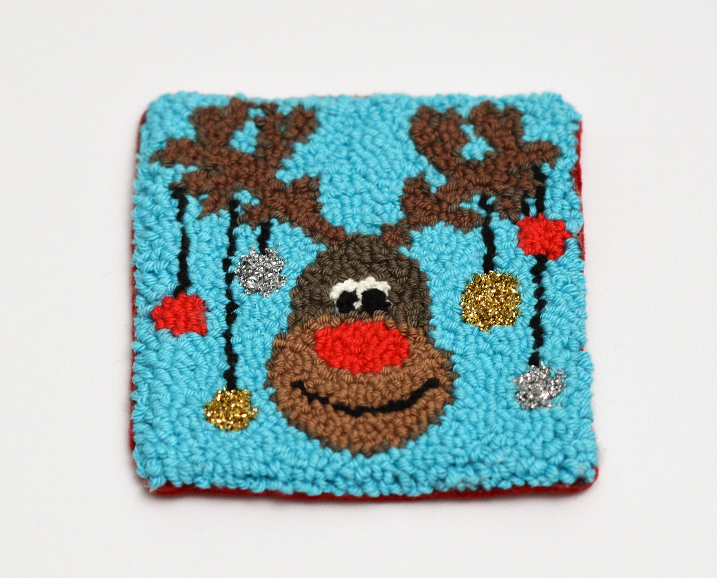 Decorative coaster with a reindeer design on a blue background