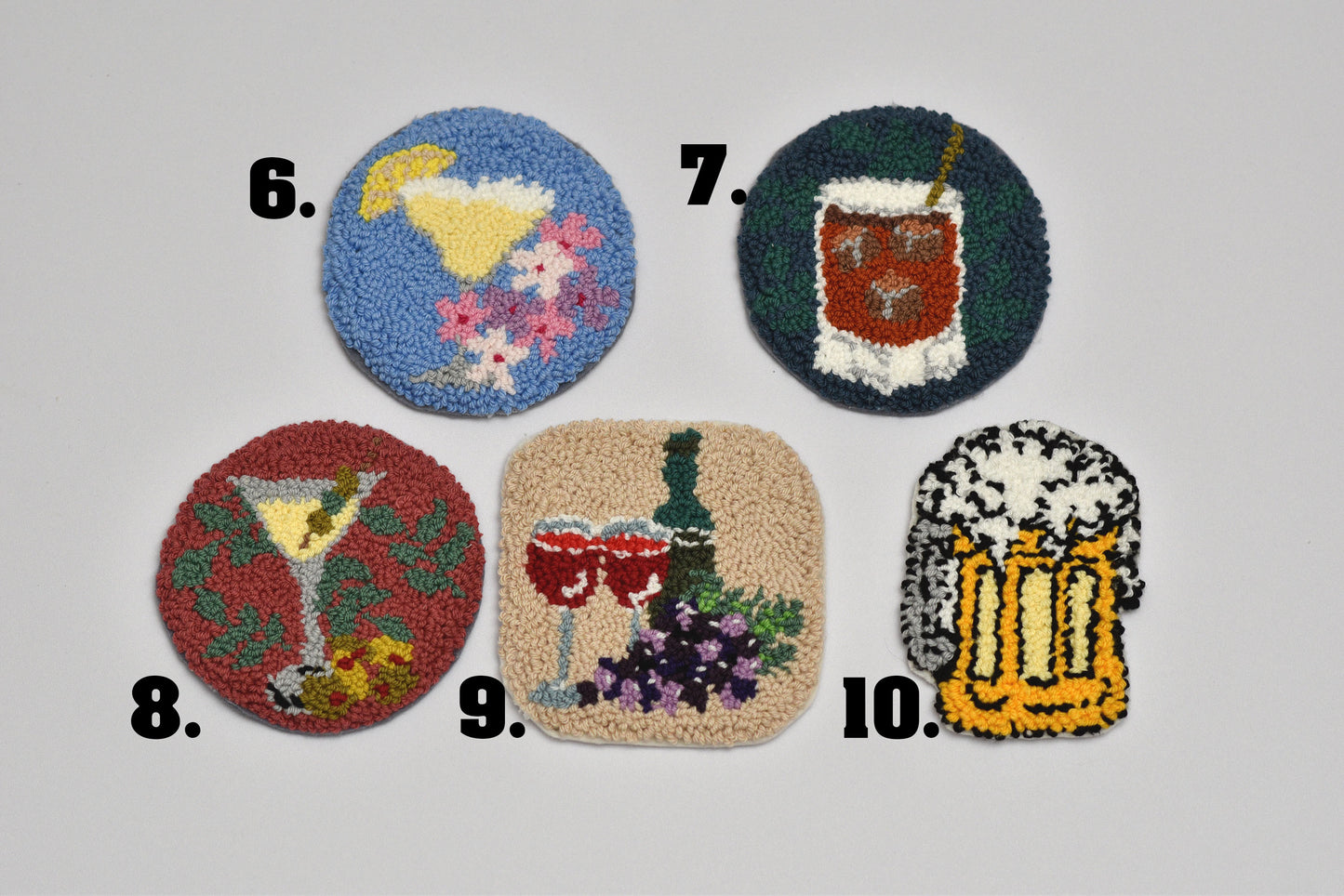 Set of five decorative coasters with various designs (Margarita, whiskey, Martini, Red wine and Beer Mug ) on a light gray background.