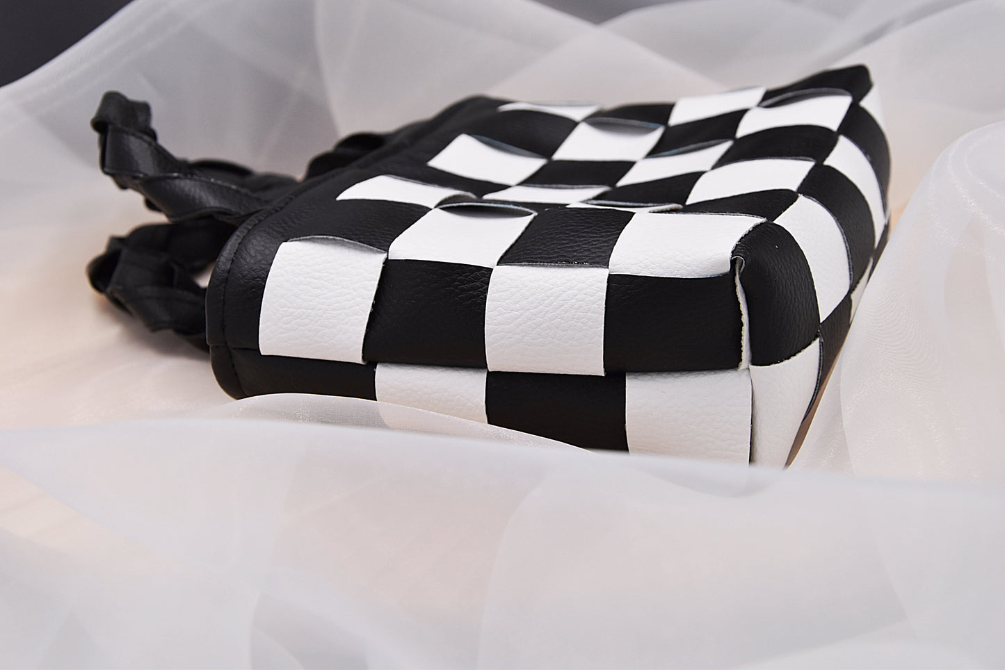 Mini faux leather hand-woven handbag in black and white with braid handle