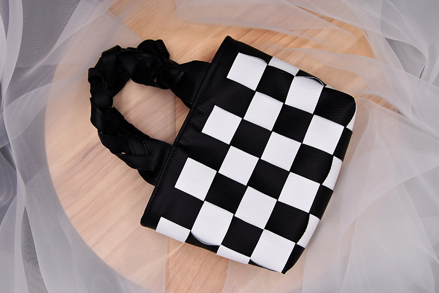 Mini faux leather hand-woven handbag in black and white with braid handle