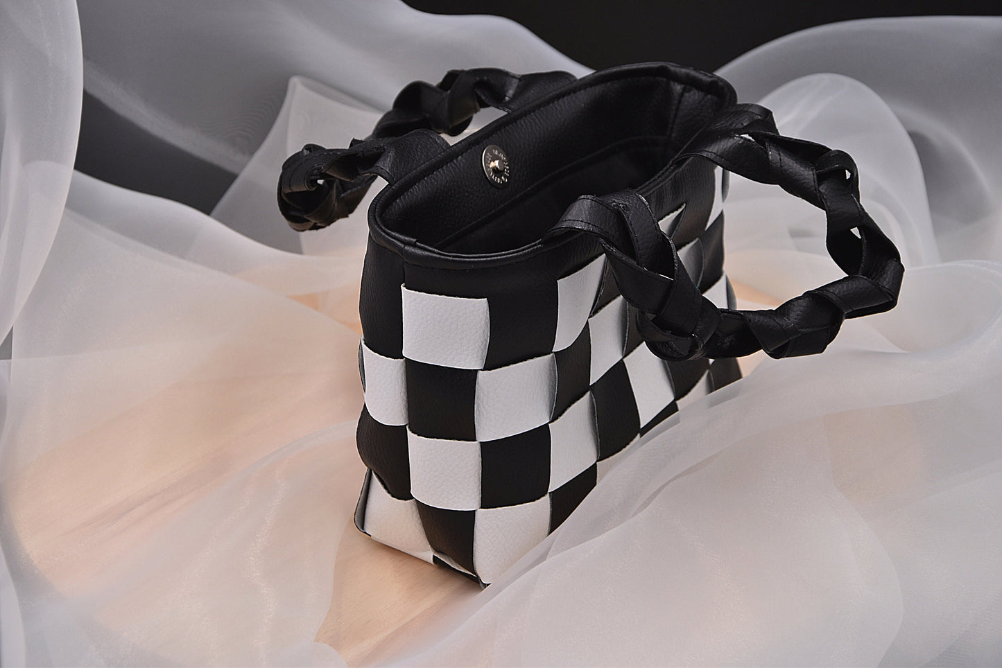 Mini faux leather hand-woven handbag in black and white with braid handle