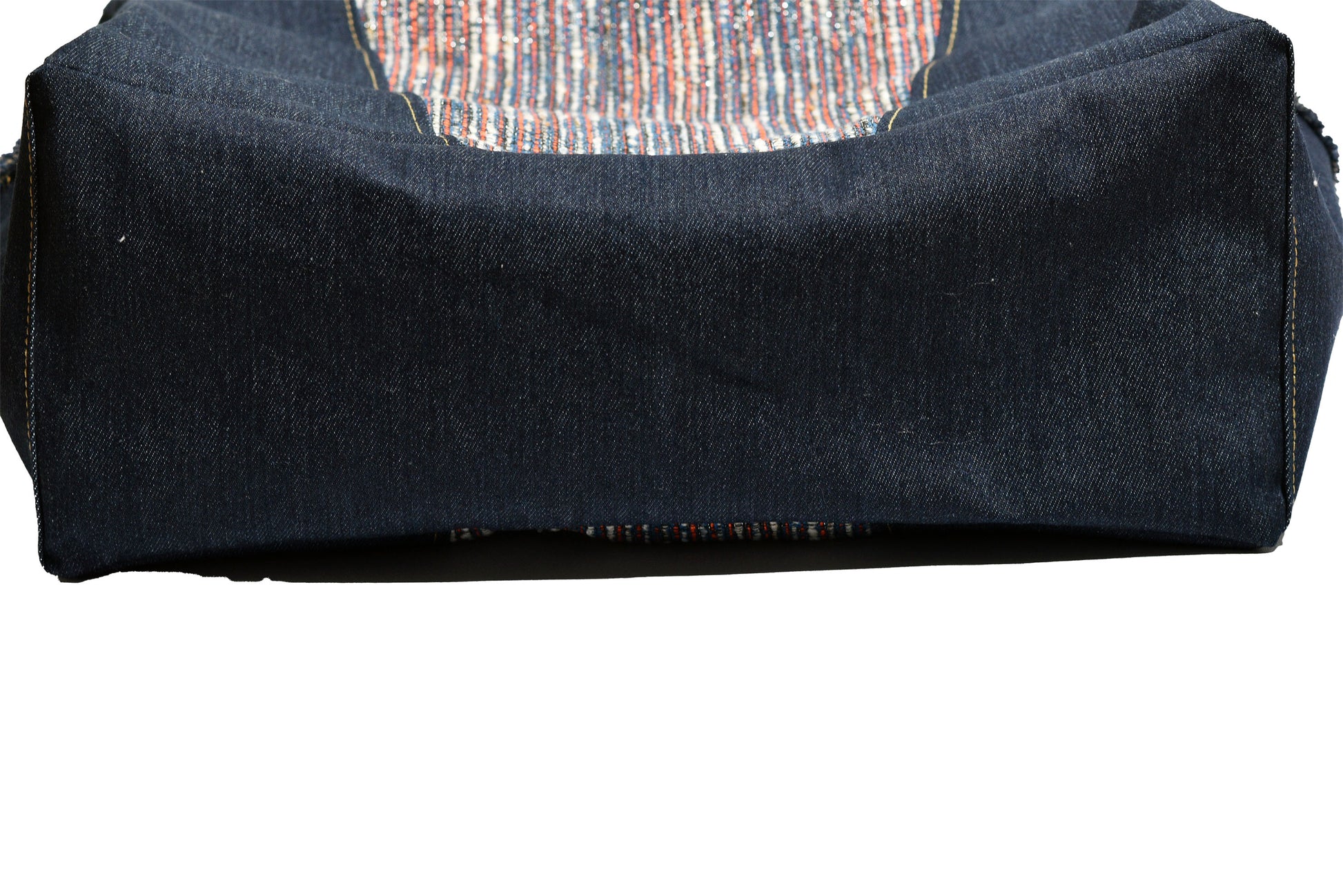 Folded dark blue fabric with a circular pattern on a white background